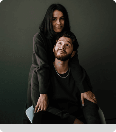 A couple sitting close, one resting against the other